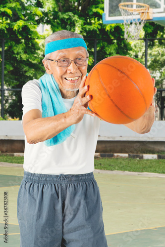 Senior man playing at the basketball court