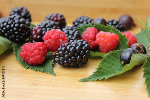 raspberries and blueberries on wooden table