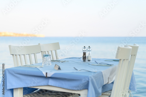 cafe tables on the sea mediterranean embankment. selective focus © Ksenia