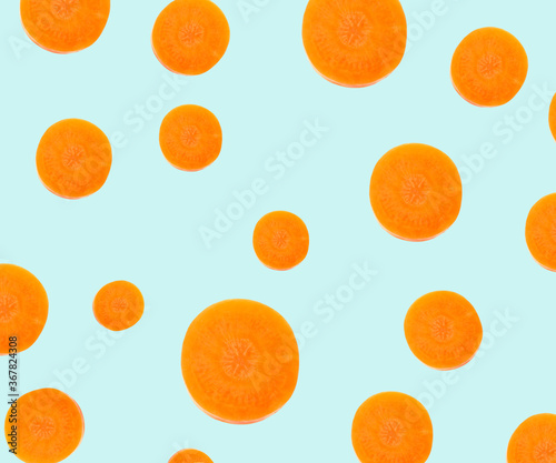 Pattern design with carrot slices on pale light blue background