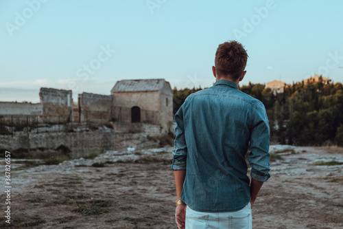 Young man walking trough the ruin of the city