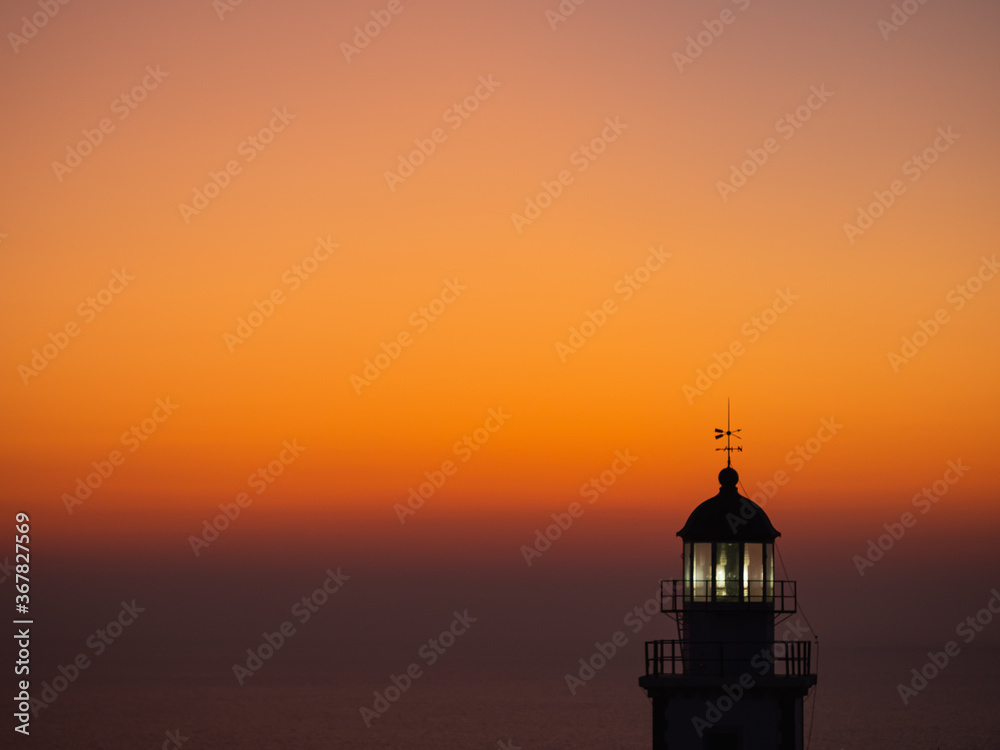 seascape with silhouette of a lighthouse at sunset in soft focus, watercolor effect