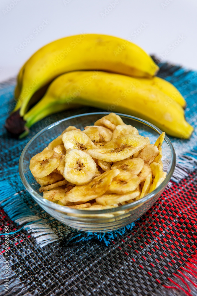 Healthy snacks dry bananas in a bowl. Dried fruits. vertical photo Healthy snacks dry bananas in a bowl. Dried fruits. vertical photo