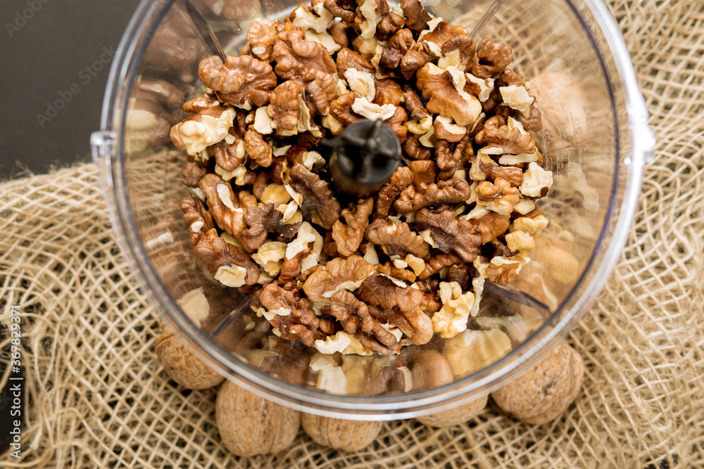 Tasty walnut kernels plastic container of a small kitchen blender. for a tasty dessert. Tasty walnut kernels plastic container of a small kitchen blender. for a tasty dessert.