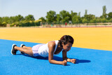 Female athlete doing abdominals in outdoor sports facilities. Space for text. Concept of sport and healthy life.