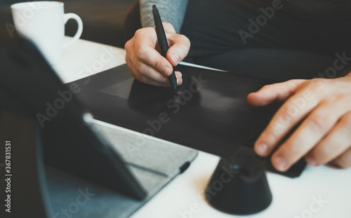 Graphic designer using electronic drawing tablet at home. photo