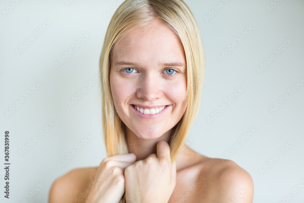 Portrait of beautiful blonde female model smiling with amazing blue eyes isolated against white background. Portrait of beautiful blonde female model smiling with amazing blue eyes isolated against white background.