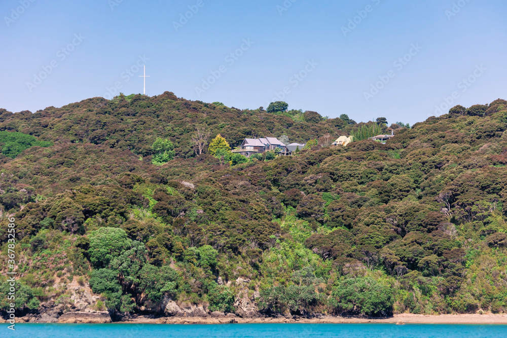 Coastline with natural beach, trees and residential buildings in Russell, New Zealand Coastline with natural beach, trees and residential buildings in Russell, New Zealand