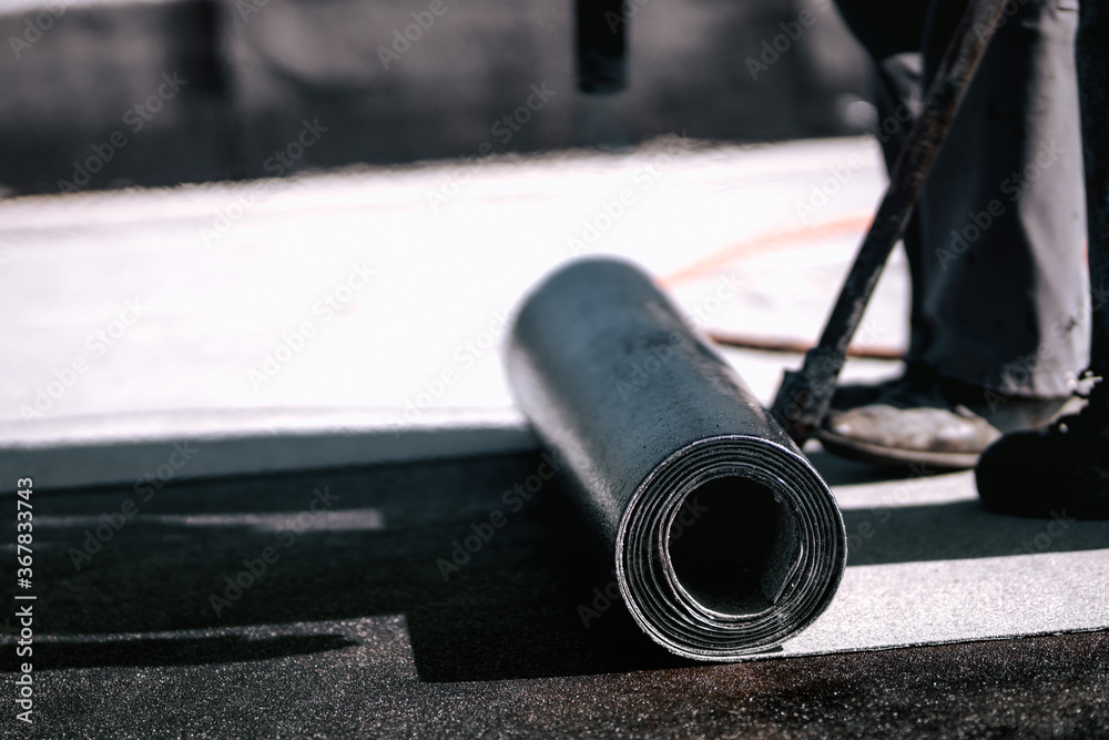 Waterproof insulation with bituminous membrane system. Professional workers waterproofing house construction site. Waterproof insulation with bituminous membrane system. Professional workers waterproofing house construction site.