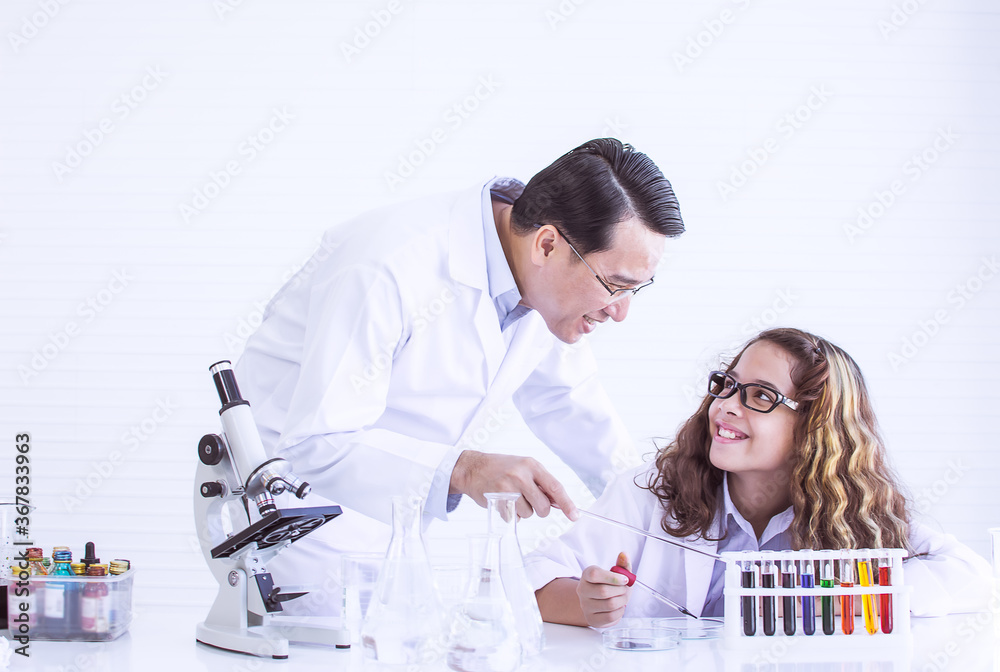 Teacher teaching science to caucasian girl at school Teacher teaching science to caucasian girl at school