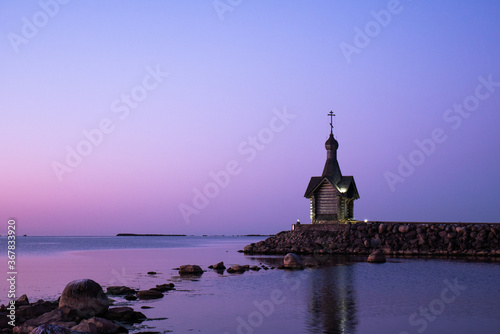 The church against a beautiful pink purple sky. Chapel on the ocean. stone coast.