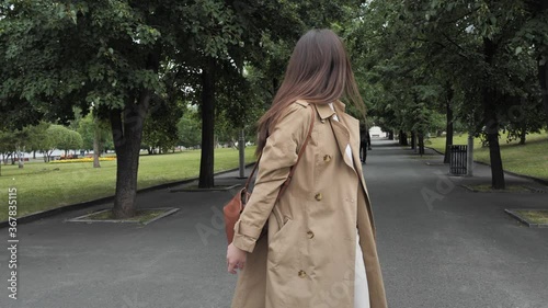 Cute girl stylishly dressed fun whirls, posing for the camera in the city park. High quality 4k footage