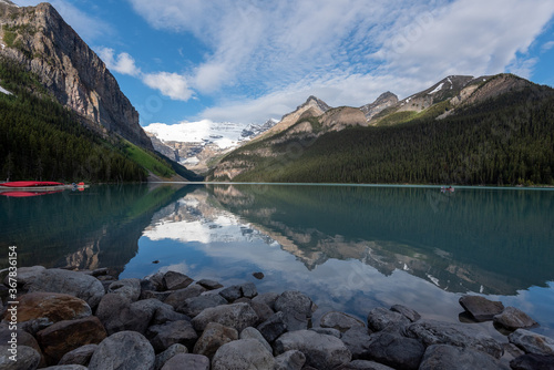 Lake Louise on a sunny day with clouds and mountains and beautiful reflections in the water
