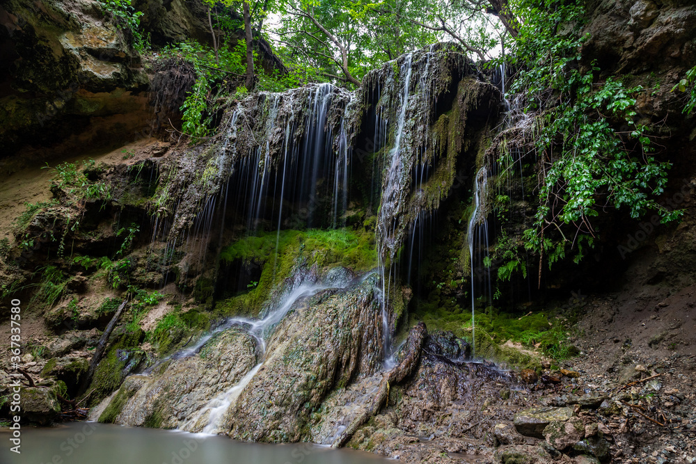 Fototapeta premium Beautiful waterfall with a lagoon for relaxation in the summer.