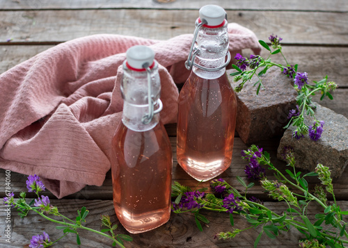 Fotografi Frischer Lavendelsirup in dekorativen Einweckflaschen abgefüllt auf Holz
