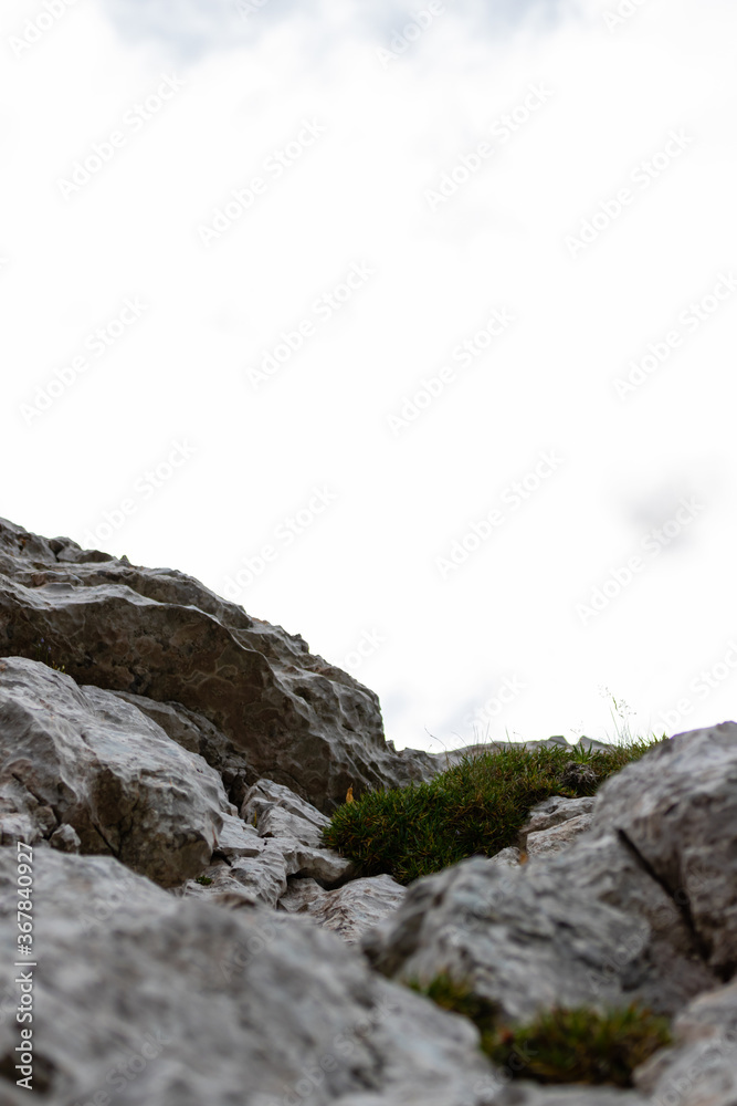 Steep mountain face of grey rock with some moss growing on it. Steep mountain face of grey rock with some moss growing on it.