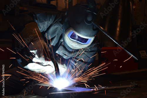 Fotografie Industrial steel welder in factory technical, The welder is welding metal