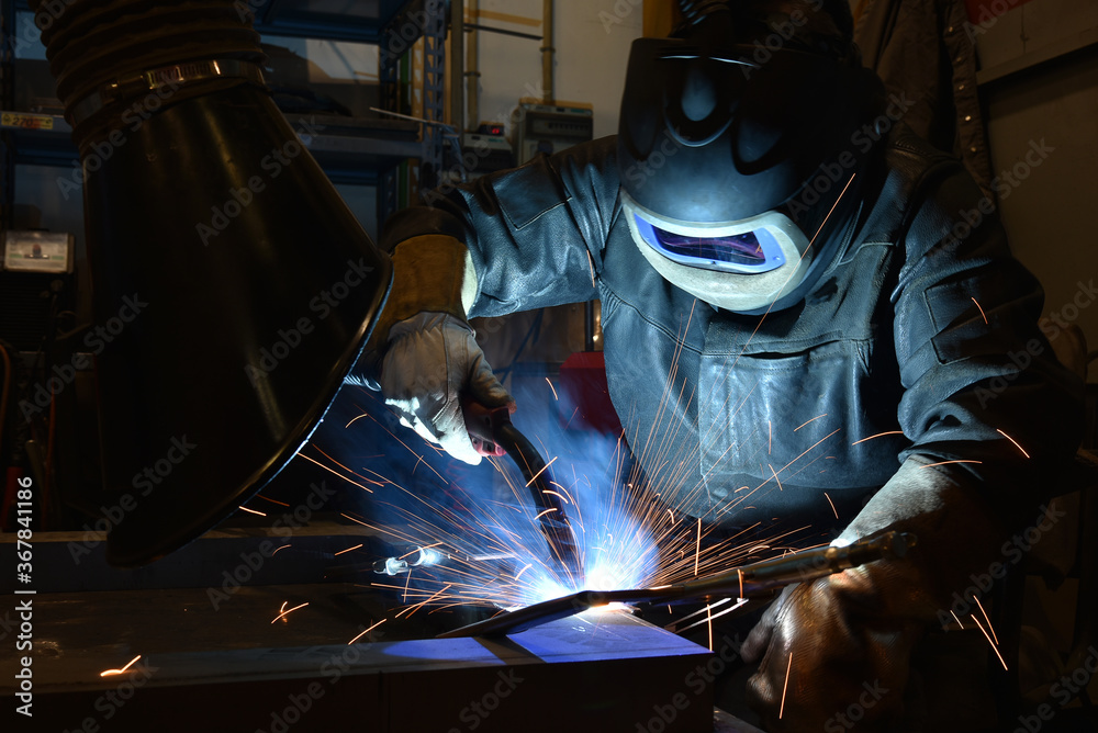 Industrial steel welder in factory technical, The welder is welding metal. Industrial steel welder in factory technical, The welder is welding metal.
