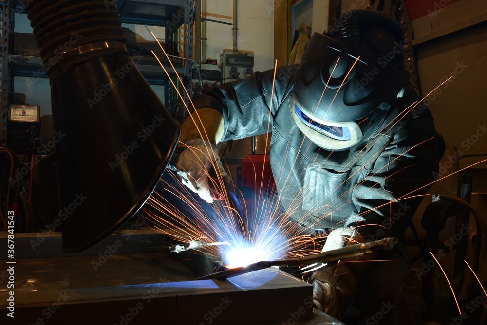 Industrial steel welder in factory technical, The welder is welding metal. Industrial steel welder in factory technical, The welder is welding metal.
