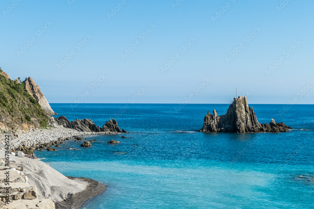 small rock in the sea with a Christian cross in Riva Trigoso