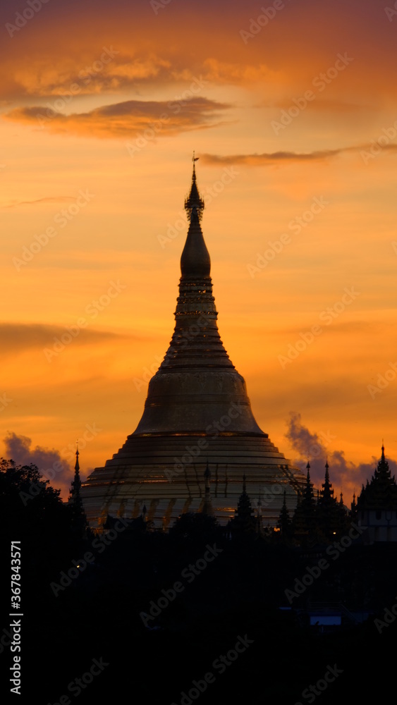 The stunning Shwedagon pagoda in Yangon, Myanmar. A stunning red filling the sky around this exciting building.