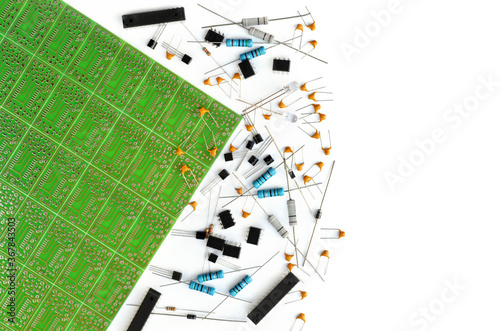 Various electronic components arranged near green electronic circuit board on white background with copy space. Close-up, top view photo