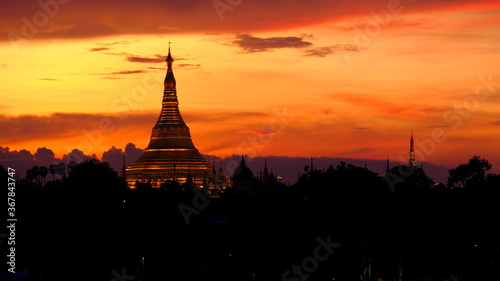 The stunning Shwedagon pagoda in Yangon, Myanmar. A stunning red filling the sky around this exciting building.