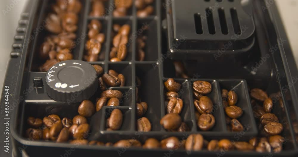 Coffee beans slowly going down into grinder, home brewing a hot drink, machine Coffee beans slowly going down into grinder, home brewing a hot drink, machine