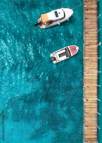 Tourist pleasure yacht and motor boat on the sea near the pier. Top view © maykal