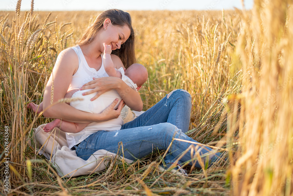 Beautiful young mother and her baby girl at the wheat field in sunny day, Czech republic Beautiful young mother and her baby girl at the wheat field in sunny day, Czech republic