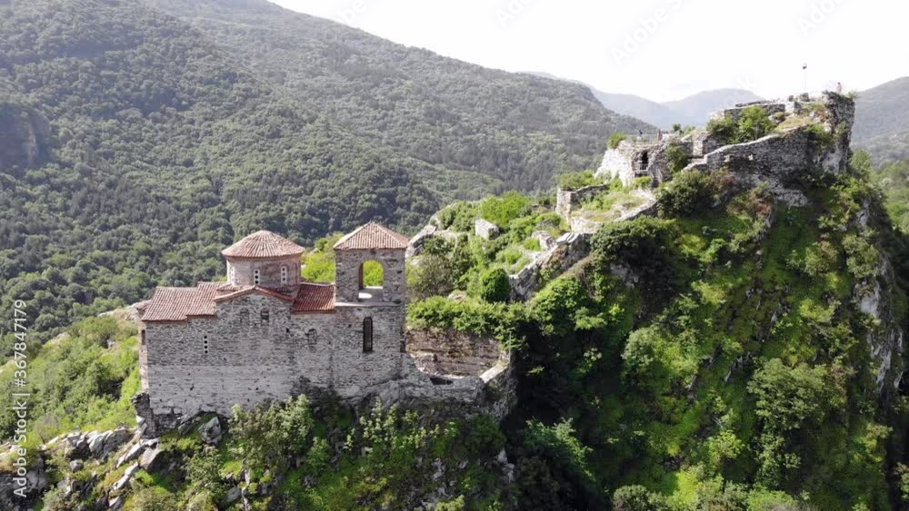 Medieval Fortress on a hill in eastern Europe, Bulgaria. Bulgarian antique and heritage stronghold fortification on a rock. Aerial video of a holy place and monastery. Tourist place with forest. Drone Medieval Fortress on a hill in eastern Europe, Bulgaria. Bulgarian antique and heritage stronghold fortification on a rock. Aerial video of a holy place and monastery. Tourist place with forest. Drone