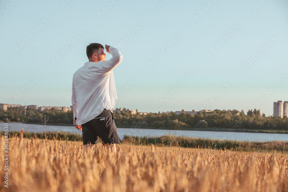 man walking on sunset in wheat field man walking on sunset in wheat field
