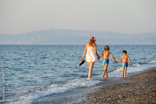 a mother with children walks on the seashore