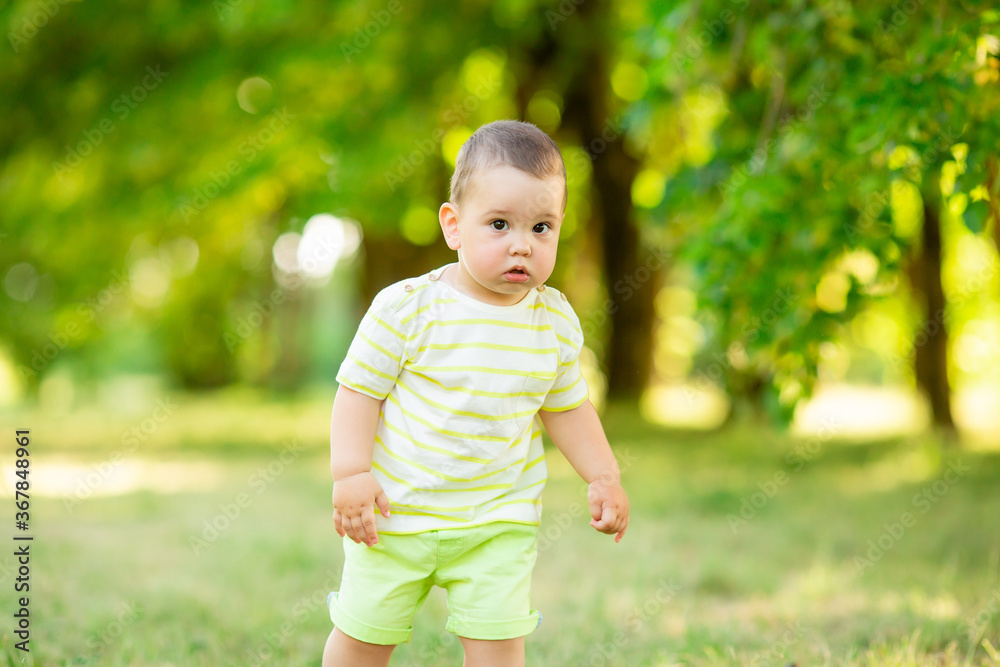baby boy one year smiles in the summer on a walk in the park. Children's Lifestyle baby boy one year smiles in the summer on a walk in the park. Children's Lifestyle