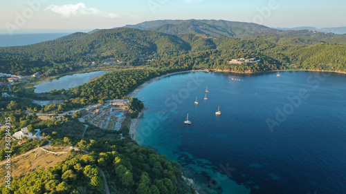 Aerial drone photo of beautiful popular organised sandy bay, turquoise beach and natural preserve lake with pine trees of Koukounaries, Skiathos island, Sporades, Greece