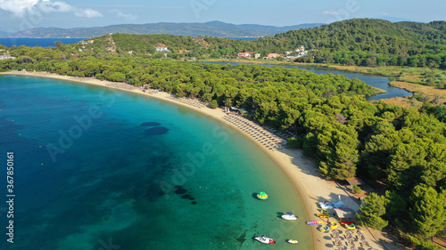 Aerial drone photo of beautiful popular organised sandy bay, turquoise beach and natural preserve lake with pine trees of Koukounaries, Skiathos island, Sporades, Greece © aerial-drone