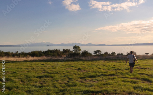 young man walking in the field at sunset, 