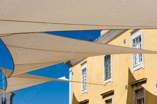Canvases stretched for sun protection in the alleys of the old town of Faro, Algarve, Portugal