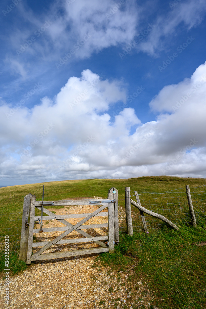 South Downs National Park, Sussex, UK near Firle Beacon. A gate and fence on the route of the South Downs Way. The South Downs Way is a national trail popular with walkers.