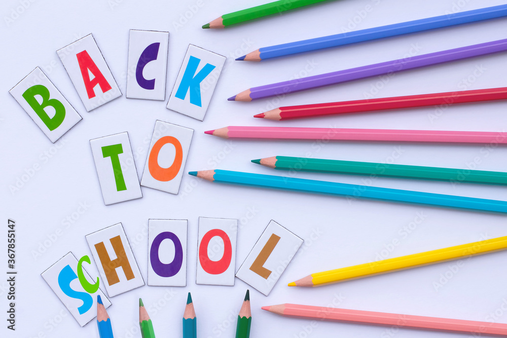 Back to school. Letters and colorful pencils on a white background. Flat lay. Education concept Back to school. Letters and colorful pencils on a white background. Flat lay. Education concept