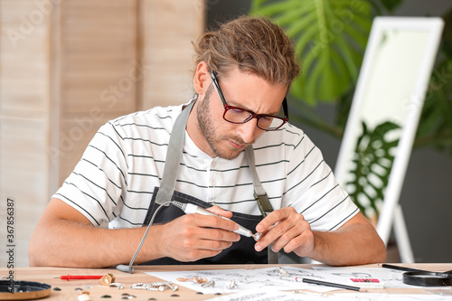 Male jewelry designer worki...