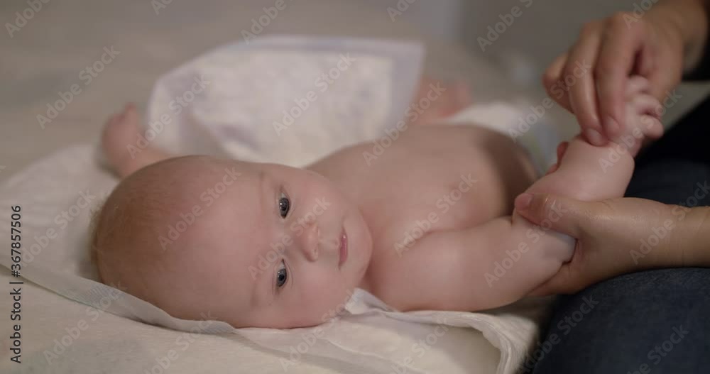 View of cute reaction of baby during massaging his arm and palm by massagist View of cute reaction of baby during massaging his arm and palm by massagist