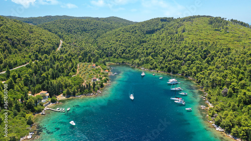 Aerial drone photo of safe small fjord harbour of Mplo near bay of Panormos a popular yacht and sail boat anchorage with calm sea covered with pine trees, Skopelos island, Sporades, Greece photo
