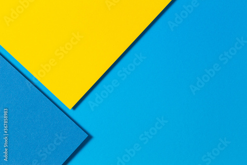 Abstract color papers geometry flat lay composition background with yellow and blue tones