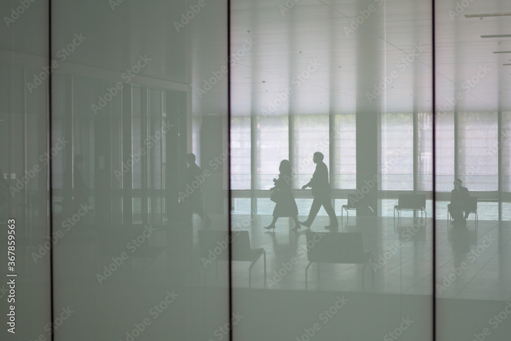 Fototapeta premium Silhouetted businesspeople in corporate office lobby
