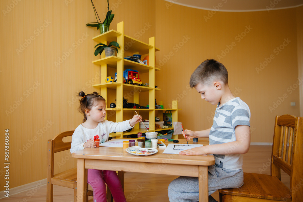 A boy and a girl play together and paint. Recreation and entertainment. Stay at home A boy and a girl play together and paint. Recreation and entertainment. Stay at home