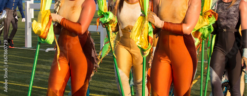 Marching band flag twirler. woman dancer in costumes on a field with a marching band.