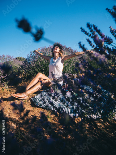 Young woman having picnic in lavender field