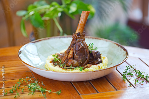 Braised lamb shank on the mashed potato in the restaurant photo