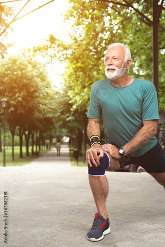 Senior man stretching legs before workout at park